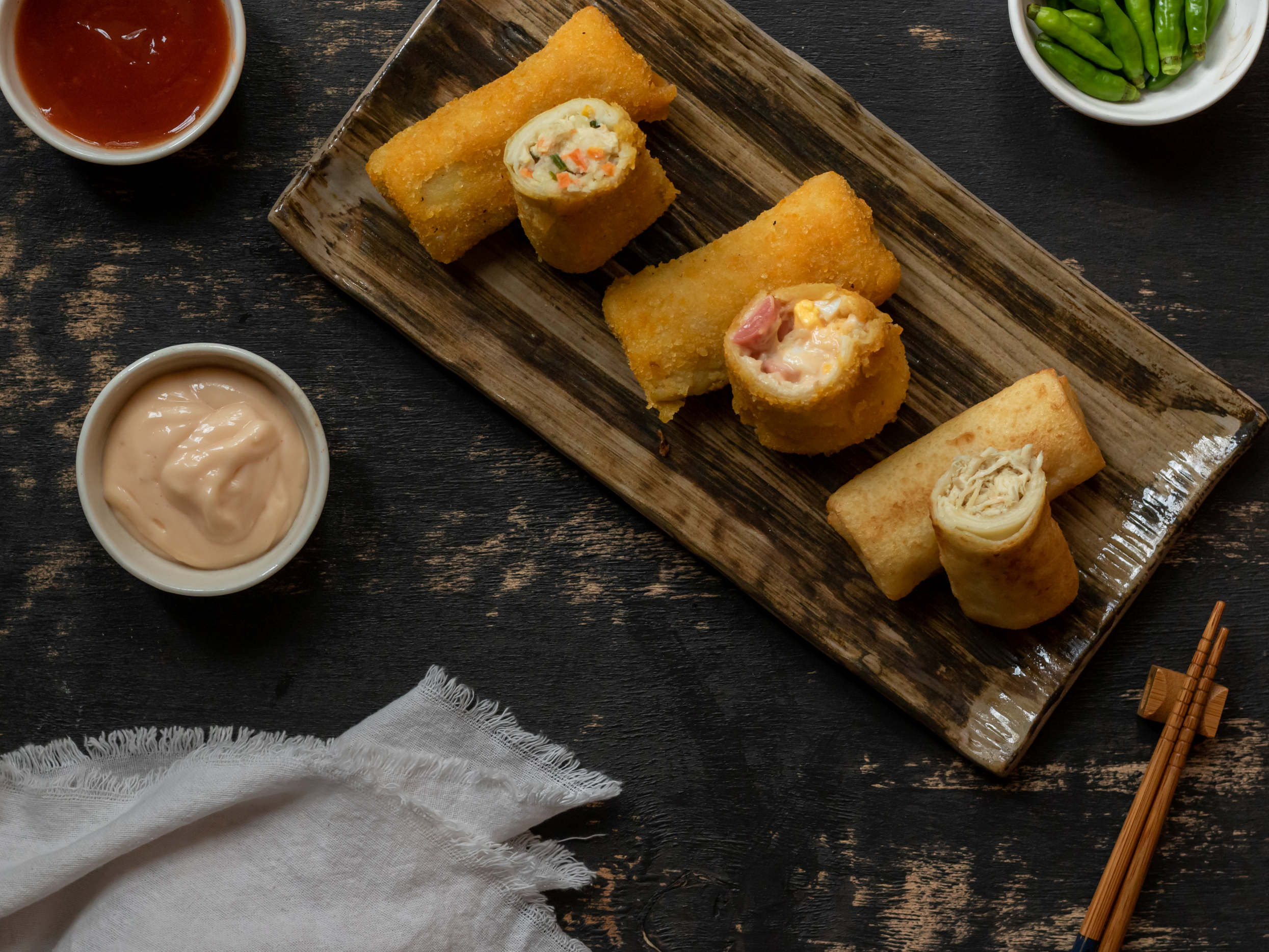 Risol mayo tampil memikat dengan balutan kulit keemasan yang renyah, disusun rapi di atas piring dengan saus mayo atau cabai sebagai aksen visual. Sentuhan garnish seperti daun parsley atau irisan sayuran segar menambah kesan modern dan menggugah selera, menjadikan hidangan sederhana ini terlihat istimewa di setiap penyajiannya.